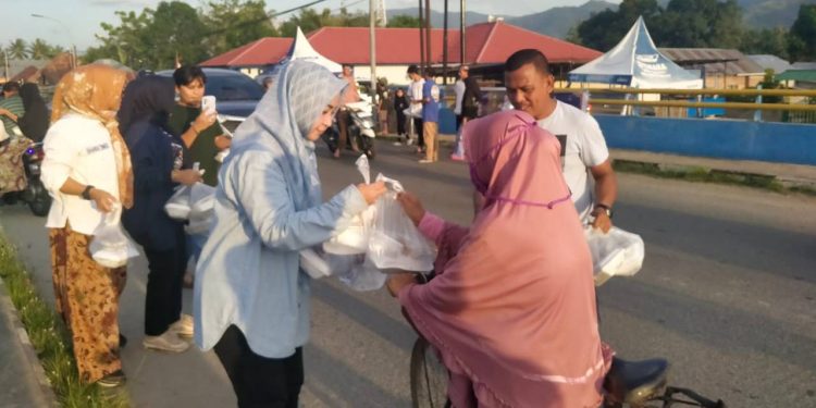 Pemilik PT. Azwa Utama Rakhmatiyah Deu saat membagikan paket makanan di Ulahuta, Kecamatan Kabila, Kabupaten Bone Bolango, Ahad (9/4/2023) (muhajir/gopos)