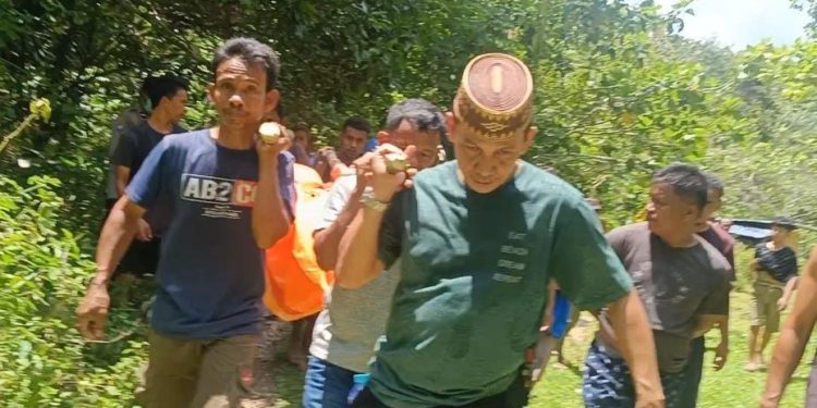 Kapolsek Tapa Iptu Atmal Fauzi bersama warga saat mengevakuasi jasad korban menggunakan tandu, Rabu (26/4/2023). (F. istimewa)