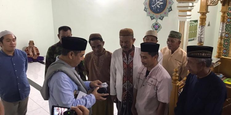Bupati Hamim Pou saat menyerahkan bantuan pengeras suara disalah satu masjid yang ada di Desa Longalo, Kecamatan Bulango Utara, Senin (10/4/2023). (Foto Fauzi/Magang Diskominfo)