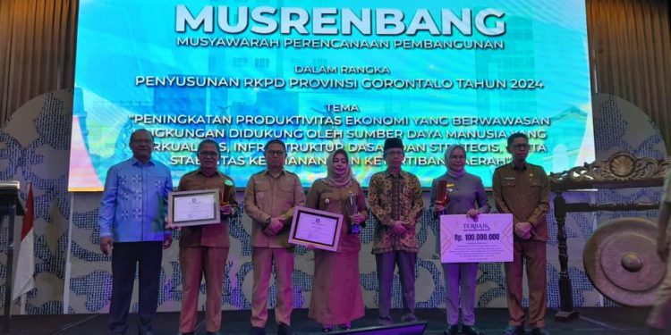 Wabup Merlan S. Uloli saat menerima dua penghargaan saat pelaksanaan Musyawarah Perencanaan Pembangunan ( Musrenbang) tingkat Provinsi Gorontalo di Ballroom Hotel Aston Gorontalo, Senin (10/4/2023). (Foto Aisiyah/Magang Diskominfo)