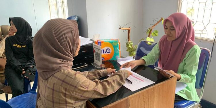 Amalia Nadjamudin salah seorang tenaga honorer di Dinas Kominfo Bone Bolango saat menerima THR dari Baznas Bone Bolango. (Foto Indra/Gopos)