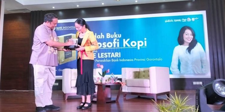 Kepala Perwakilan BI Gorontalo, Dian Nugraha (kiri) menyerahkan cinderamata kepada penulis buku, Dee Lestari, dalam acara bedah buku filosofi kopi yang diselenggarkan KPw BI Gorontalo, Rabu (31/5/2023). (foto: Lukman Polimengo)
