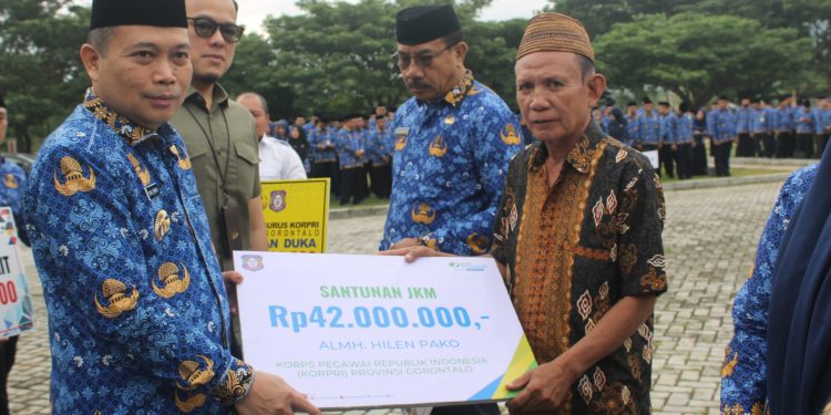 Penjagub Gorontalo, Ismail Pakaya didampingi Kepala BPJS Ketenagakerjaan Cabang Gorontalo, Arif Budiman saat menyerahkan santunan Jaminan Kematian (JKM) dari BPJS Ketenagakerjaan Cabang Gorontalo kepada ahli waris Almarhumah Hilen Pako yang merupakan anggota Korpri Provinsi Gorontalo, Rabu (17/5/2023). (Foto Istimewa)
