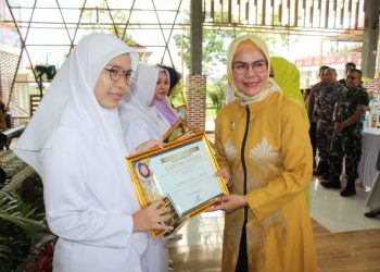 Ketua GOW Bone Bolango, Merlan S. Uloli saat menyerahkan piagam penghargaan Kartini Award kepada 14 perempuan tangguh pada Puncak Peringatan Hari Kartini, Selasa (9/5/2023). (Foto Yudi/Sespri Wabup)