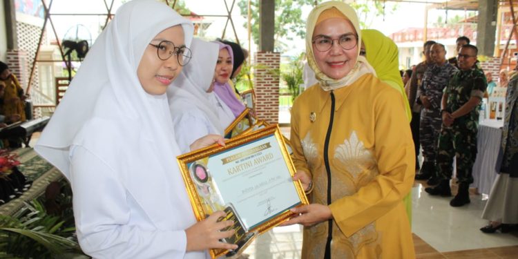Ketua GOW Bone Bolango, Merlan S. Uloli saat menyerahkan piagam penghargaan Kartini Award kepada 14 perempuan tangguh pada Puncak Peringatan Hari Kartini, Selasa (9/5/2023). (Foto Yudi/Sespri Wabup)