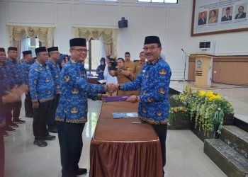 Ketua Dewan Pengurus Korpri Bone Bolango, Ishak Ntoma saat menerima surat keputusan dari Ketua Dewan Pengurus Korpri Provinsi Gorontalo, Mohamad Nadjamudin usai menjalani proses pengukuhan di Aula BPMP Provinsi Gorontalo, Selasa (23/5/2023). (Foto Indra/Gopos)