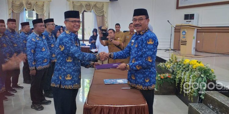 Ketua Dewan Pengurus Korpri Bone Bolango, Ishak Ntoma saat menerima surat keputusan dari Ketua Dewan Pengurus Korpri Provinsi Gorontalo, Mohamad Nadjamudin usai menjalani proses pengukuhan di Aula BPMP Provinsi Gorontalo, Selasa (23/5/2023). (Foto Indra/Gopos)