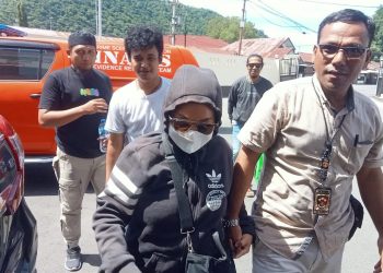 Tante Ika yang membawa kabur bocah 6 tahun saat digelandang ke Polresta Gorontalo Kota, Sabtu (6/5/2023). (F. Sari/gopos)