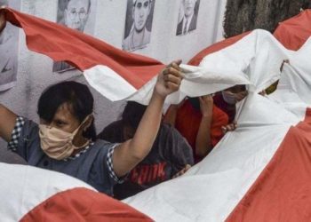 Beberapa orang memegang bendera nasional Indonesia saat mengikuti tradisi cuci bendera merah putih di Jenggala, Ciamis, Jawa Barat, Jumat (14 Agustus 2020). (ANTARA PHOTO/Adeng Bustomi/aww)
