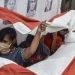 Beberapa orang memegang bendera nasional Indonesia saat mengikuti tradisi cuci bendera merah putih di Jenggala, Ciamis, Jawa Barat, Jumat (14 Agustus 2020). (ANTARA PHOTO/Adeng Bustomi/aww)