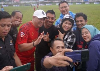 Hamim Pou dan Tatong Bara saat diburu untuk foto bersama oleh masyarakat yang menonton jalannya pertandingan silaturahmi Sepak Bola antara Tim Pemerintah Kabupaten Bone Bolango versus Pemerintah Kota Kotamobagu, Jumat (16/6/2023). (Foto Adit/Prokopim)