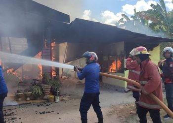 Petugas pemadam kebakaran Kabupaten Gorontalo berupaya memadamkan kobaran api dalam peristiwa kebakaran di Kelurahan Hutuo, Kecamatan Limboto, Kabupaten Gorontalo, Senin (5/6/2023).