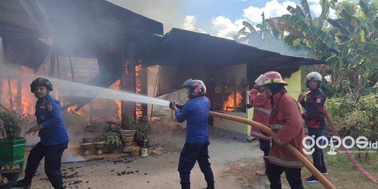 Petugas pemadam kebakaran Kabupaten Gorontalo berupaya memadamkan kobaran api dalam peristiwa kebakaran di Kelurahan Hutuo, Kecamatan Limboto, Kabupaten Gorontalo, Senin (5/6/2023).