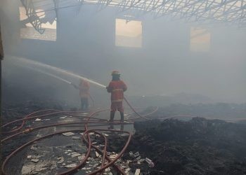 Salah satu petugas Damkar masih terus berupaya memadamkan titik-titik api di gudang sepatu milik toko Utama Shoes Kota Gorontalo, Jumat (16/6/2023). (putra/istimewa)