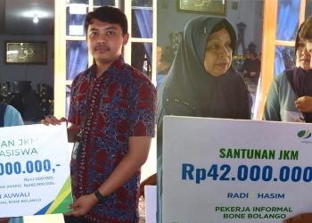 Muhammad Naufal Halim, selaku Petugas Administrasi Peserta Kantor BPJS Ketenagakerjaan Cabang Gorontalo, saat menyerahkan santunan JKM dan manfaat beasiswa kepada ahli waris almarhum Radi Hasim dan almarhum Usman Auwali, pada prosesi doa arwah ke-40 hari dari meninggalnya almarhum Radi Hasim, di Desa Biluango, Kecamatan Kabila Bone, Kabupaten Bone Bolango, Kamis (22/6/2023). (Foto AKP)
