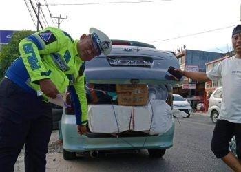 Seorang anggota Polantas Polda Gorontalo mendapati salah satu mobil yang menggunakan knalpot brong. (F polda)
