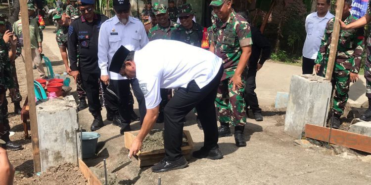 Bupati Hamim Pou saat peletakan batu pertama pembangunan jalan rabat beton program TMMD ke-117 di Desa Kemiri, Kecamatan Bonepantai, Rabu (12/7/2023). (Foto Istimewa)