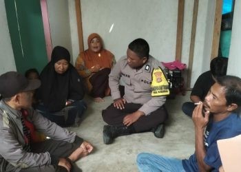Bhabinkamtibmas Briptu Irhan Hamzah saat mendampingi keluarga korban percobaan bunuh diri, Senin (25/7/2023). (istimewa)