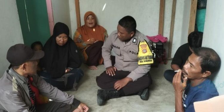 Bhabinkamtibmas Briptu Irhan Hamzah saat mendampingi keluarga korban percobaan bunuh diri, Senin (25/7/2023). (istimewa)