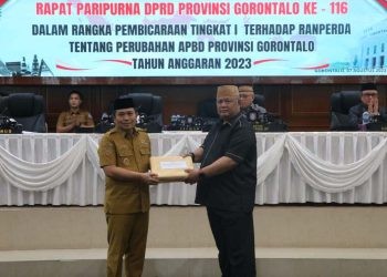 PJ Gubernur Gorontalo, Ismail Pakaya (kiri) menyerahkan dokumen Ranperda perubahan APBD ke Wakil Ketua I Deprov Gorontalo, Kris Wartabone, Senin (7/8/2023).(Humas Deprov Gorontalo)