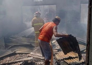 Petugas Damkar saat berupaya memadamkan api di gedung perpustakaan SDN 1 Atinggola, Jumat (25/8/2023).