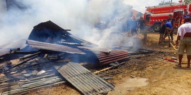 Petugas Damkar saat berupaya melakukan pendinginan di sekitar lokasi kebakaran rumah di Desa Leboto, Kecamatan Kwandang, Gorontalo Utara, agar tidak muncul titik api baru.(f. isno)