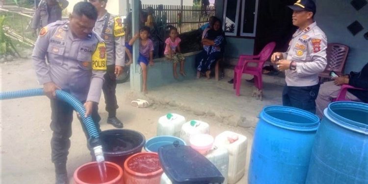 Jajaran Polsek Paguyaman Pantai saat mendistribusikan air bersih untuk warga.(f.tribrata)