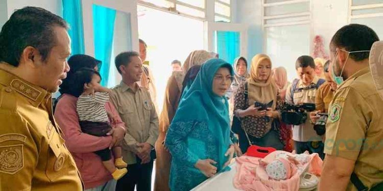 Penjabat Gubernur Gorontalo, Ismail Pakaya bersama ketua Tim penggerak PKK Provinsi, Fima Agustina membawa cucu kesayangannya berusia 2 bulan di Posyandu Cengkih 1, Kelurahan Tenda Kecamatan Hulonthalangi, Kota Gorontalo, Selasa (05/09/2023)