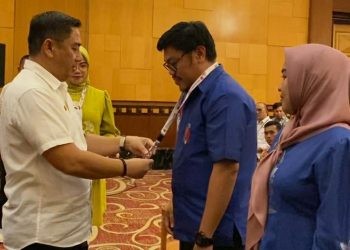 Bupati Hamim Pou saat menyematkan tanda peserta kepada peserta Bimbingan Teknis Pengelolaan Keuangan Daerah Kabupaten Bone Bolango di Swiss-Bellhotel Maleosan Manado, Kamis (7/9/2023). (Foto Sandi/Diskominfo)