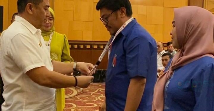 Bupati Hamim Pou saat menyematkan tanda peserta kepada peserta Bimbingan Teknis Pengelolaan Keuangan Daerah Kabupaten Bone Bolango di Swiss-Bellhotel Maleosan Manado, Kamis (7/9/2023). (Foto Sandi/Diskominfo)