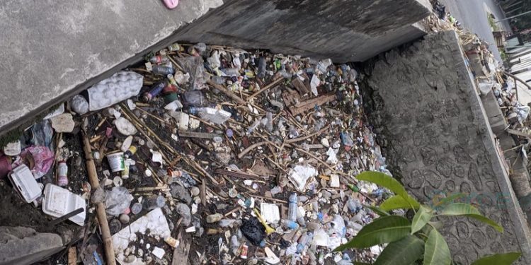 Tampak sampah telah menyumbat selokan Kalimadu yang berlokasi di Kelurahan Paguyaman, Kecamatan Kota Tengah, Kota Gorontalo.