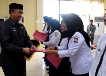 Penjabat Sekdaprov Gorontalo, Budiyanto Sidiki, menyerahkan SK kepada PPPK guru yang dilantik di aula kantor BKD Provinsi Gorontalo, Selasa (3/10/2023). (Foto : Haris)