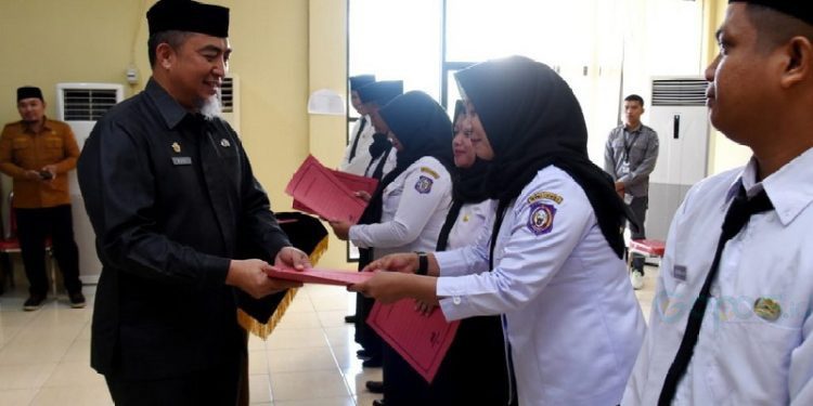 Penjabat Sekdaprov Gorontalo, Budiyanto Sidiki, menyerahkan SK kepada PPPK guru yang dilantik di aula kantor BKD Provinsi Gorontalo, Selasa (3/10/2023). (Foto : Haris)