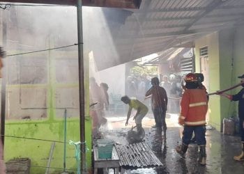 Petugas pemadam kebakaran berusaha memadamkan kobaran api dalam kebakaran sebuah rumah di Jl. Jhon A Katili (eks Jl. Andalas) Kota Gorontalo. (isno/gopos)