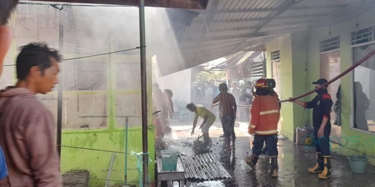 Petugas pemadam kebakaran berusaha memadamkan kobaran api dalam kebakaran sebuah rumah di Jl. Jhon A Katili (eks Jl. Andalas) Kota Gorontalo. (isno/gopos)
