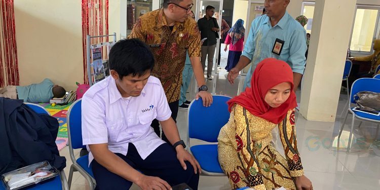 : Plt Kepala Dinas Sosial P3APPKB Bone Bolango, Fredy Lasut didampingi Ketua Pokja Bidang Pelatihan dan Pengembangan BKKBN Provinsi Gorontalo Hamdan A. Barmawi saat memantau para PKB dan PLKB melakukan penginputan data orientasi TPK di Aula Dinas Perpustakaan dan Kearsipan, Kamis (26/10/2023). (Foto Adit)