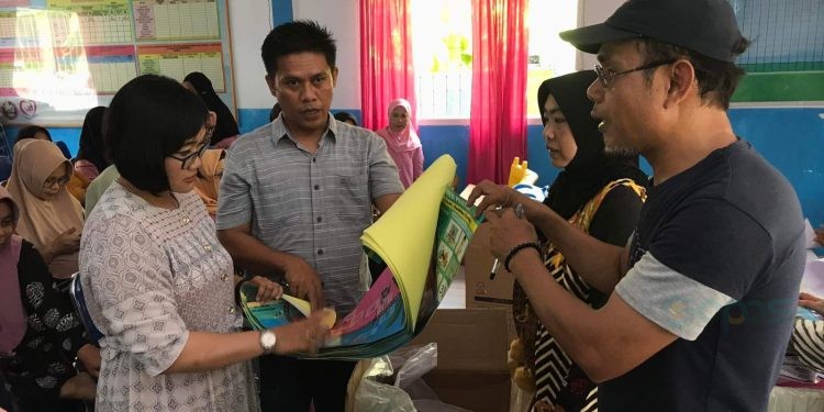 Bidan Desa Uabanga, Elok Galuh Febriani Perdana Roos saat menerima bantuan BKB KIT bantuan BKKBN Provinsi Gorontalo dari Pelaksana Bidang Keluarga Berencana dan Keluarga Sejahtera (KB - KS) DinsosP3APPKB Bone Bolango, Sarkiya Nani di Balai Penyuluh KB Bonepantai, Jumat (27/10/2023). (Foto Indra/Gopos)