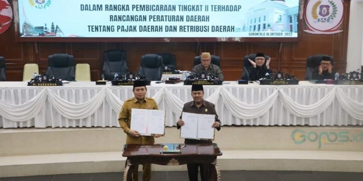 Pj Gubernur Gorontalo, Ismail Pakaya dan Ketua DPRD Provinsi Gorontalo, Paris RA Jusuf menandatangani kesepakatan pengesahan ranperda pajak dan retribusi daerah melalui rapat paripurna dewan, Senin (16/9/2023) (istimewa)