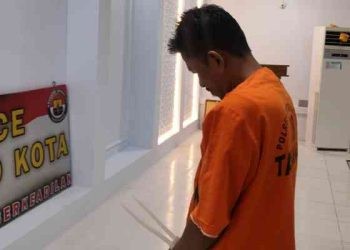 Tersangka ADE tertunduk lesu pada saat konferensi pers di Polresta Gorontalo Kota, Selasa (17/10/2023). (F. Putra/gopos)