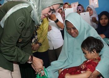 Wabup Merlan saat menyerahkan bantuan kepada balita stunting pada kegiatan Audit Kasus Stunting di Desa Motilango, Tilongkabila, Kamis (12/10/2023). (Foto Yudi)