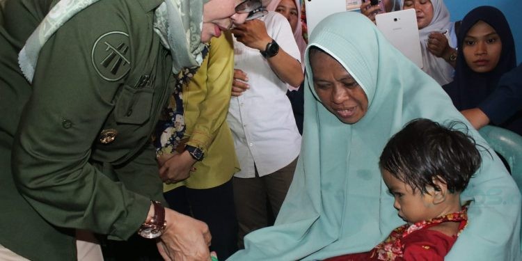 Wabup Merlan saat menyerahkan bantuan kepada balita stunting pada kegiatan Audit Kasus Stunting di Desa Motilango, Tilongkabila, Kamis (12/10/2023). (Foto Yudi)