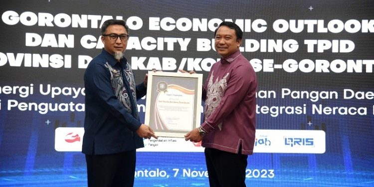 Pj Sekda Provinsi Gorontalo Budiyanto Sidiki menyerahkan piagam penghargaan kepada Kepala Perwakilan Bank Indonesia Provinsi Gorontalo Dian Nugraha pada kegiatan Gorontalo Economic Outlook dan Capacity Building TPID di Kantor Perwakilan BI Gorontalo, Selasa (7/11/2023). (F Haris/humasprov)