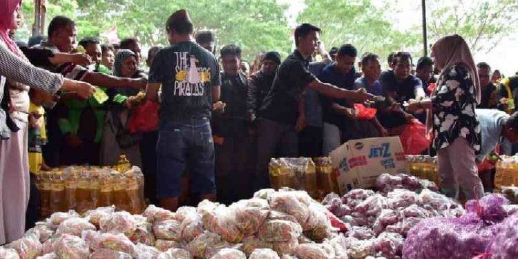 Dinas Komperindag Provinsi Gorontalo saat melayani pengemudi bentor dan ojek online pada pasar murah yang diselenggarakan di halaman kantor Diskomperindag, Jumat, (3/11/2023). Foto – Nova