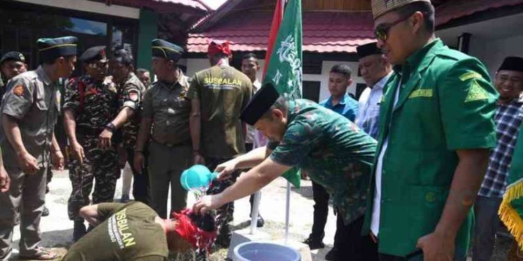 Baiat ditandai dgn penyiraman air kembang oleh Penjagub Ismail Pakaya kepada peserta PKL SUSBALAN Pimpinan wilayah GP Ansor Provinsi Gorontalo, yang berlangsung di Pentadio Resor, Telaga Biru, Minggu, (12/11/2023). Foto – Haris