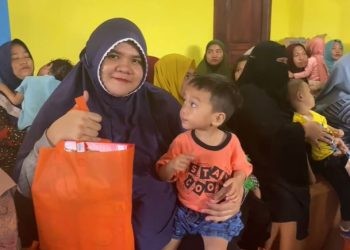 Indy Anggraini warga Kecamatan Bulango Timur saat tersenyum bahagia usai menerima bantuan intervensi stunting dari Pemerintah Kabupaten Bone Bolango. Rabu (15/11/2023). (Foto Adit)
