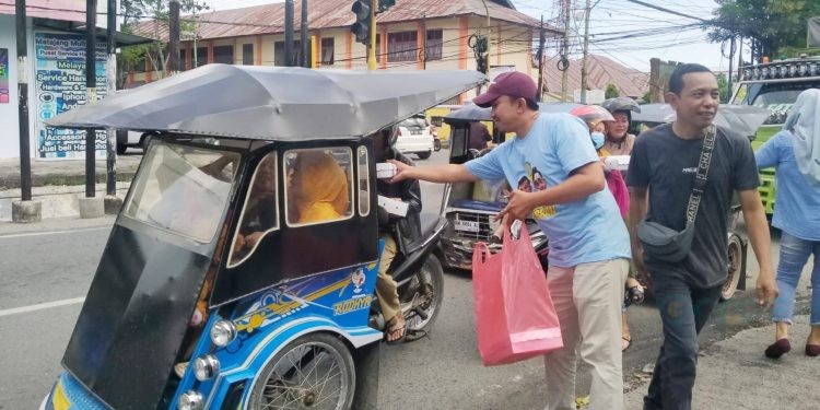 Sekretaris DPD Gerindra Gorontalo, Muhammad Nasir Majid saat membagikan nasi kotak kepada masyarakat Kota Gorontalo, Selasa (28/11/2023) (muhajir/gopos)