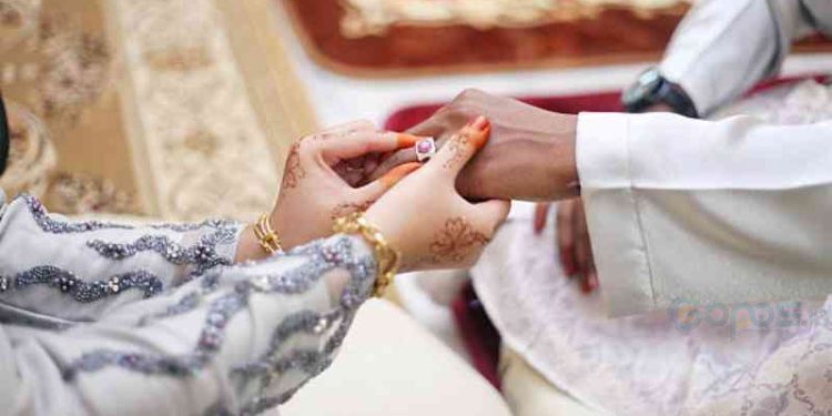 picture of man putting wedding ring on woman hand