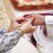 picture of man putting wedding ring on woman hand