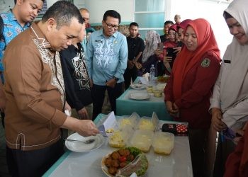 Penjagub Gorontalo Ismail Pakaya melihat displai makanan tambahan bagi balita dan ibu hamil yang disiapkan oleh kader Posyandu pada peluncuran pelaksanaan PMT di Puskesmas Sipatana, Kota Gorontalo, Kamis (9/11/2023). (F. Haris/humasprov)