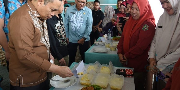 Penjagub Gorontalo Ismail Pakaya melihat displai makanan tambahan bagi balita dan ibu hamil yang disiapkan oleh kader Posyandu pada peluncuran pelaksanaan PMT di Puskesmas Sipatana, Kota Gorontalo, Kamis (9/11/2023). (F. Haris/humasprov)